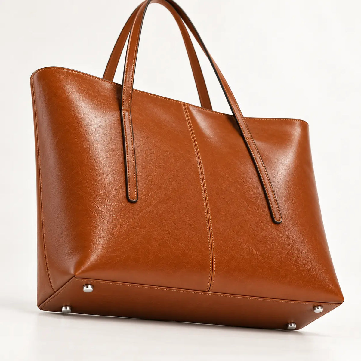 Base da Bolsa Tote Élise Caramel com quatro apoios metálicos prateados