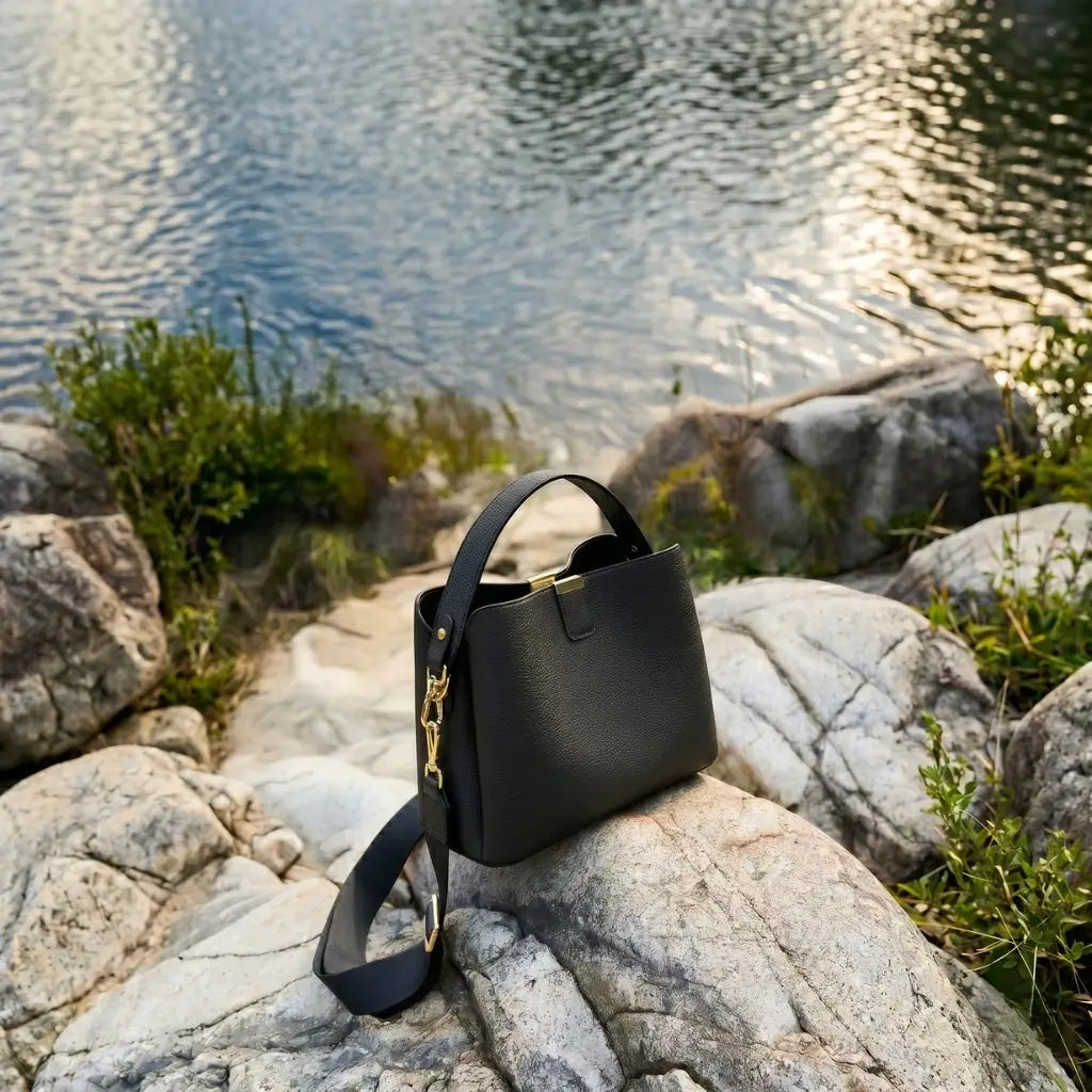 Bolsa feminina estruturada em couro preto com alça longa e detalhes dourados, design elegante e versátil para uso diário