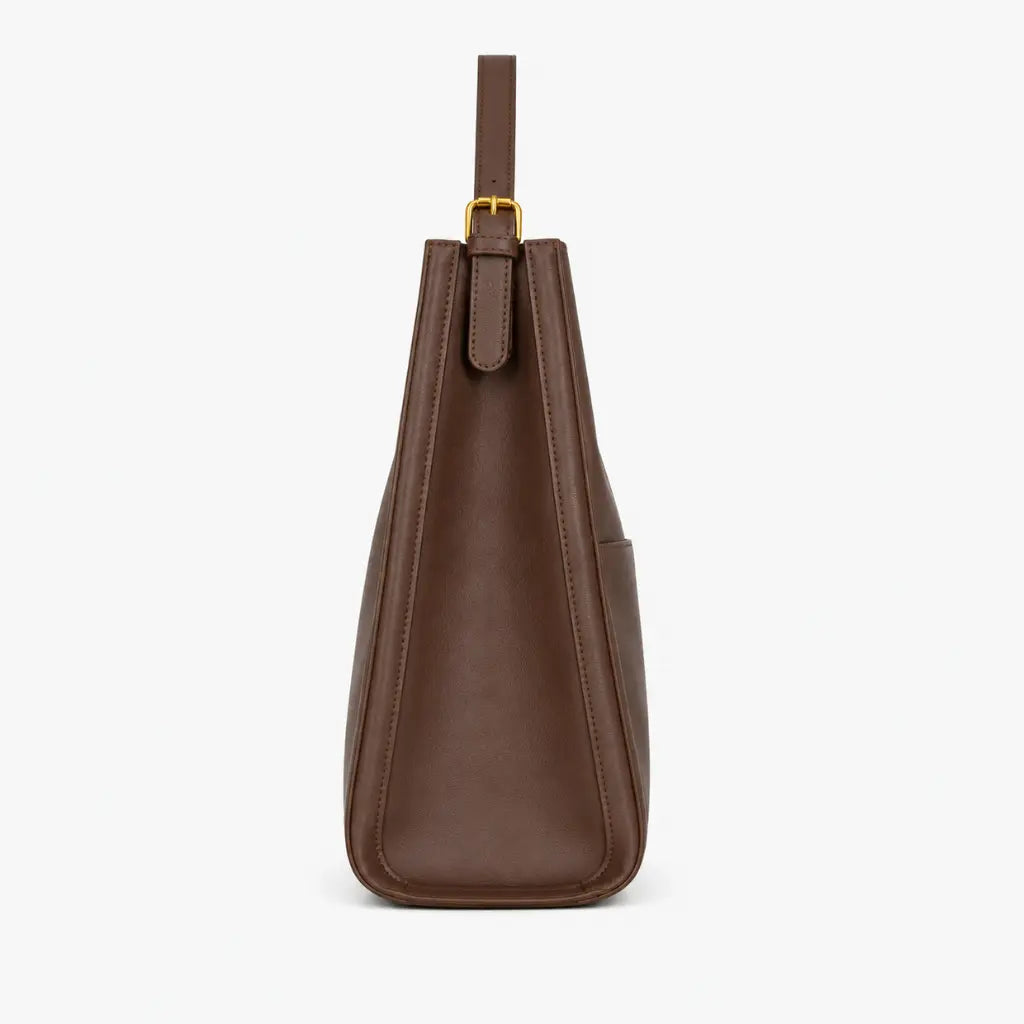 Bolsa de Ombro em Couro Eva Coffee vista lateral evidenciando profundidade de 11cm e alça ajustável, fundo branco