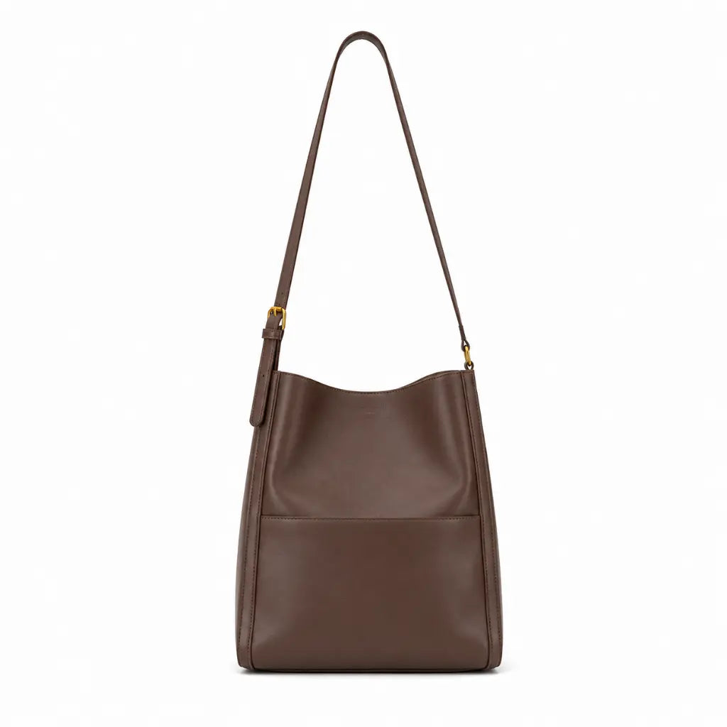 Modelo feminina usando a Bolsa de Ombro em Couro Eva Coffee no ombro em look casual com tom terroso e ferragens douradas