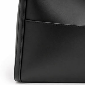 Modelo feminina usando a Bolsa de Ombro em Couro Eva Preta no ombro em look casual com couro legítimo preto e ferragens douradas