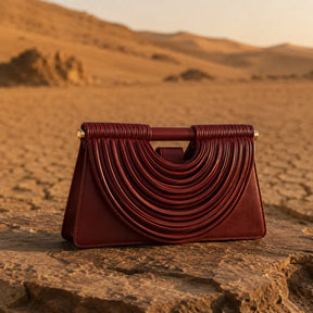 Bolsa feminina trançada borgonha Maya Nualle sobre pedra cenário deserto lifestyle