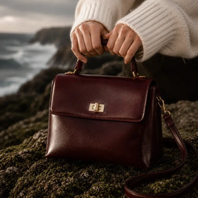 Bolsa Feminina em Couro Louise Bordô em campanha editorial sofisticada com oceano dramático ao fundo