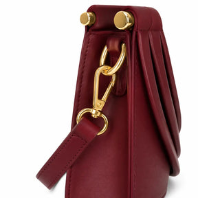 Bolsa feminina borgonha Maya Nualle detalhe lateral alça mosquetão dourado fundo branco