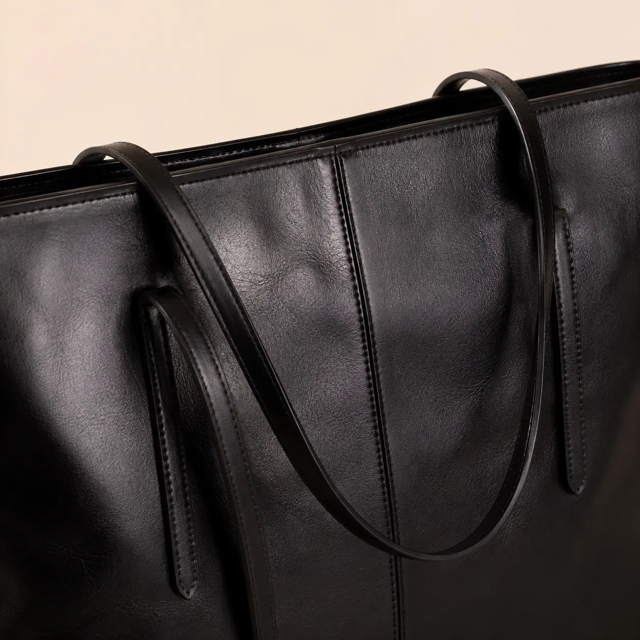 Detalhe das alças e acabamento da bolsa tote preta Nualle