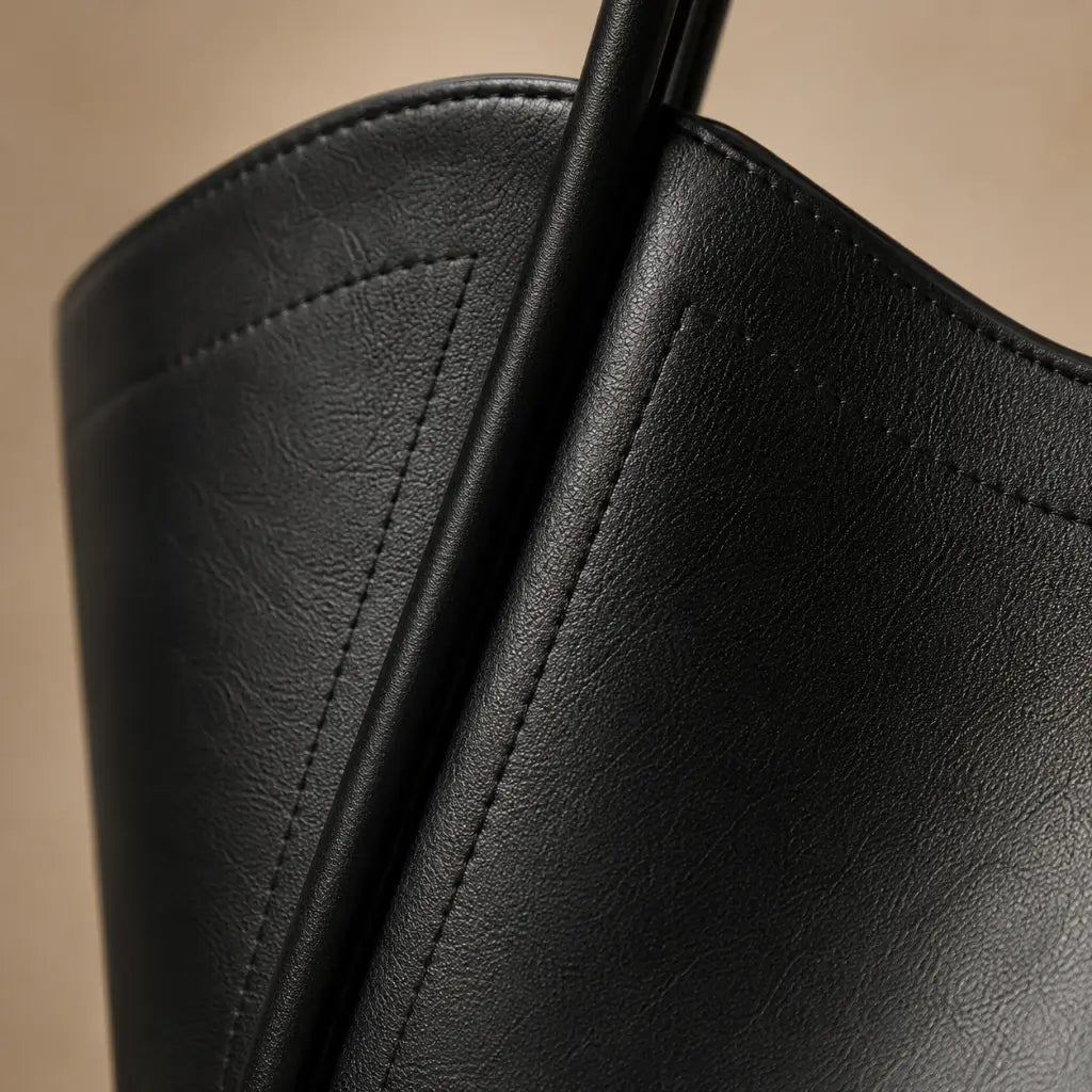 Bolsa Tote Zoé Preta — close lateral sobre mármore mostrando estrutura em couro